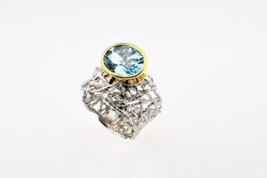 Blue topaz set in hand made, sterling silver oxidized ring, gold plated details