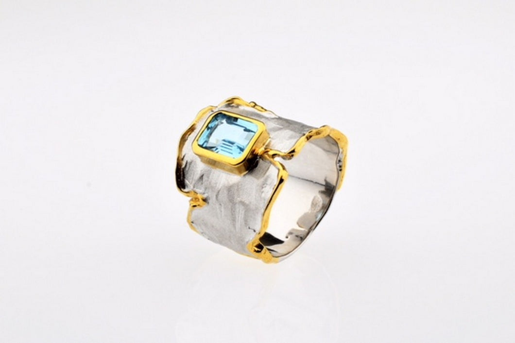 Blue topaz set in hand made, sterling silver oxidized ring, gold plated details